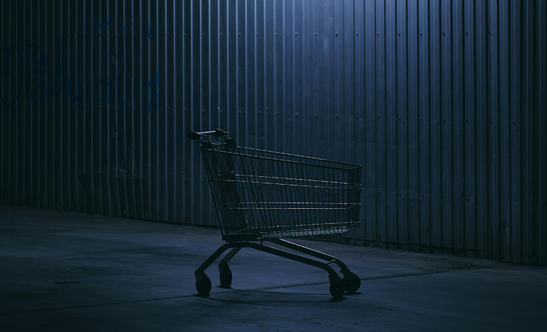 A shopping cart in a parking lot at night