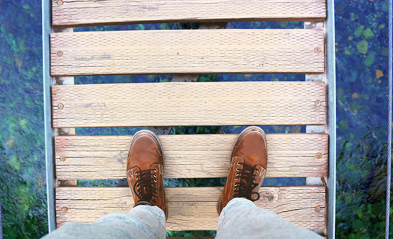 Aerial view of a person standing on a wooden bridge