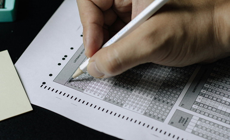 Close up of a person taking a multiple choice exam.