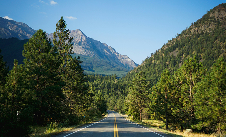 A highway running between two forested mountains.