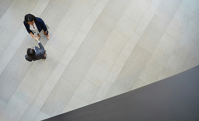 An aerial view of two professionals shaking hands making an agreement.