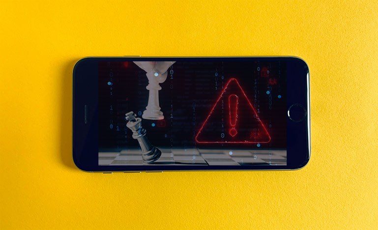 A smartphone with an image of chess and an alarm symbol.