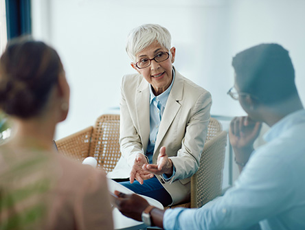 A senior couple listening to a professional providing guidance.