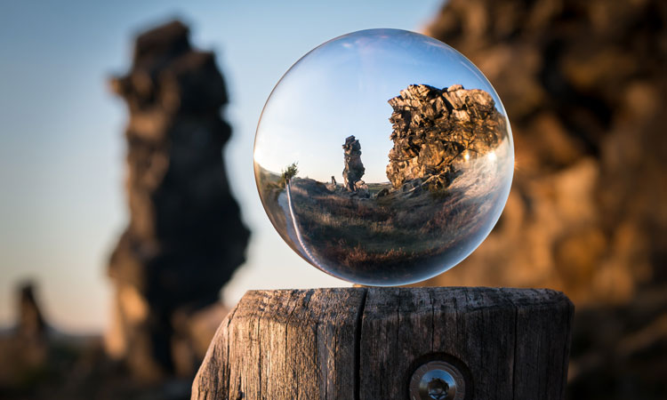 Glass sphere on a wooden post magnifying the desert background