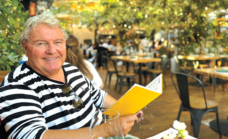 Tony Wilson, KC sitting in a bistro