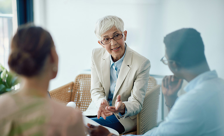 A senior couple listening to a professional providing guidance.