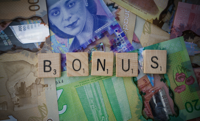 Canadian currency with "BONUS" spelled out in Scrabble letters.