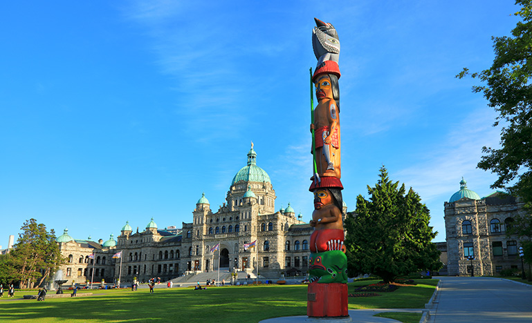 An Indigenous totem in front of the BC legislature building.