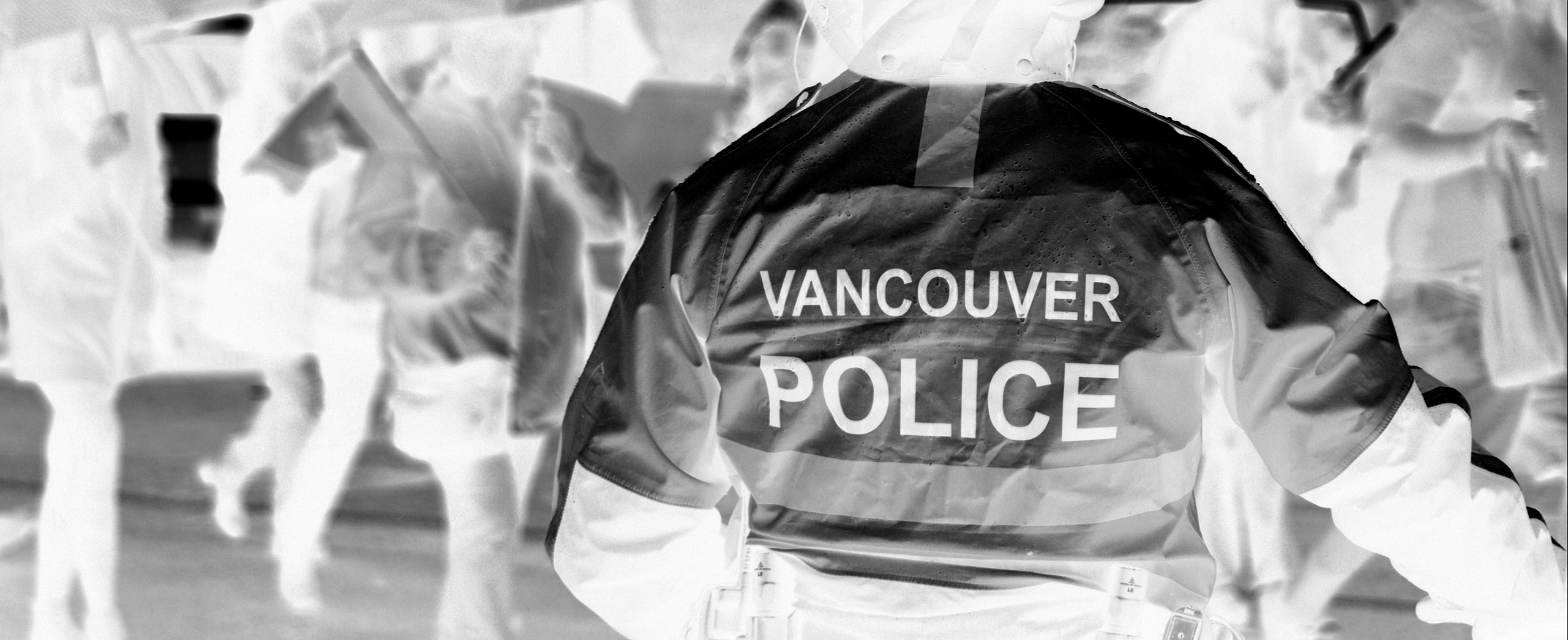 A Vancouver police officer standing in the rain.