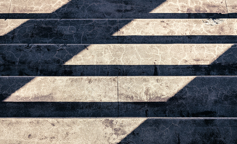 The sun casting a shadow on concrete steps