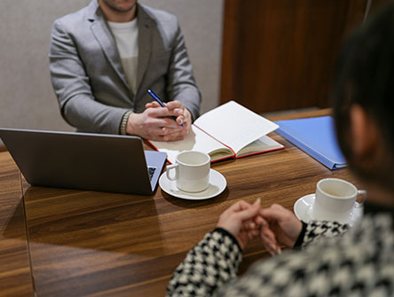 Two professionals sitting across a table having a meeting.
