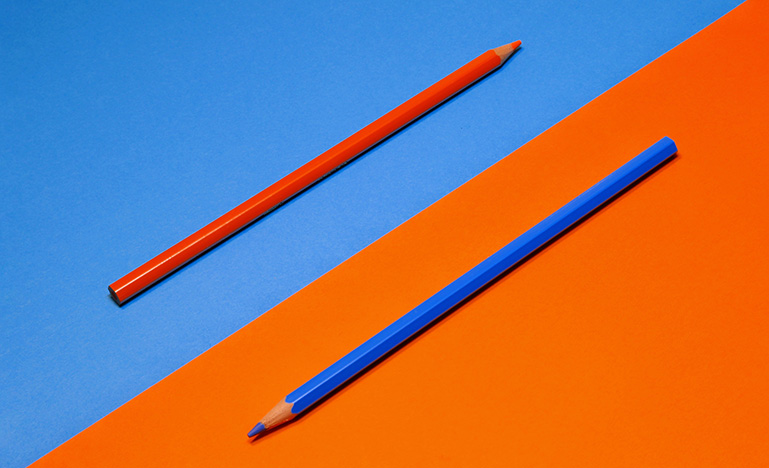 Orange and blue pencils on blue and orange background