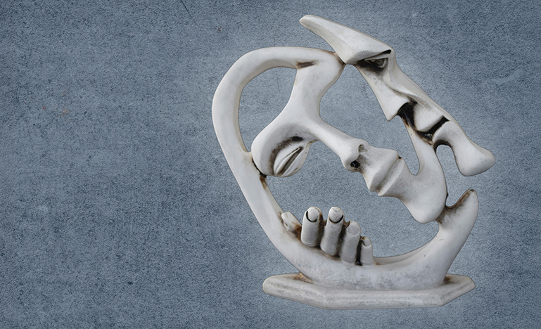 An abstract sculpture of two people in a close embrace.